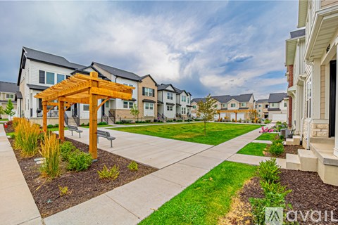 A residential area with a walkway and a wooden pergola.