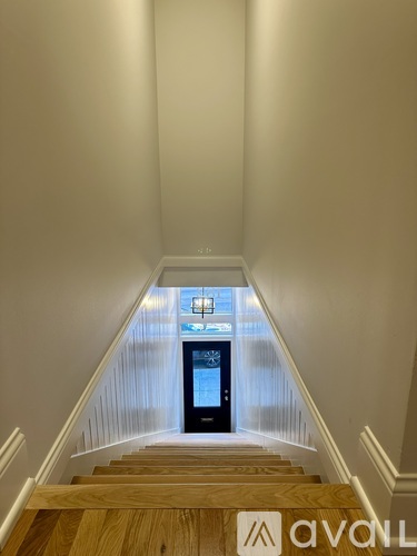 A staircase with wooden steps leading to a black box on the floor.