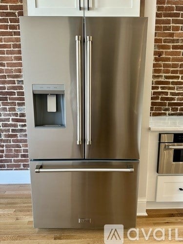 A stainless steel fridge with a water and ice dispenser built into the door.