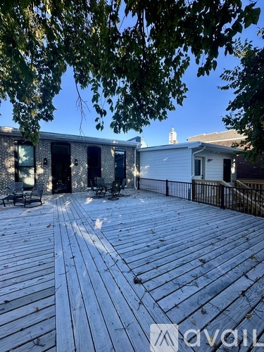 A wooden deck with a table and chairs is surrounded by trees.