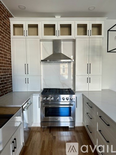 A kitchen with white cabinets and a stainless steel oven.