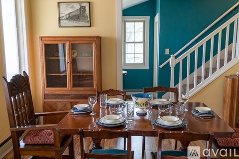 A dining room with a wooden table set for a meal.