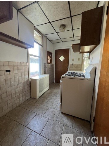 A kitchen with a white fridge, a white dishwasher, and a white washing machine.