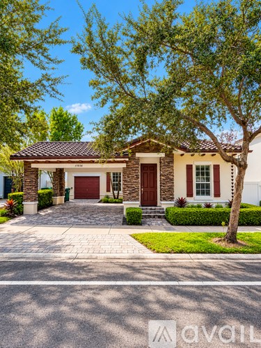A house with a red door and a tree in front.