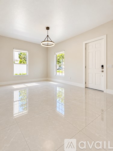 A large, empty room with a white door and windows.