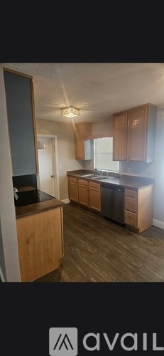 A kitchen with wooden cabinets and a black countertop.