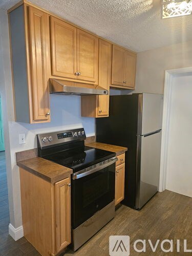 A kitchen with wooden cabinets and black appliances.