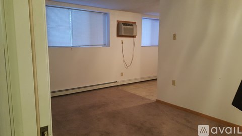 A room with a window and a wall-mounted air conditioner unit.