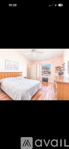 A bedroom with a bed, dresser, and window.