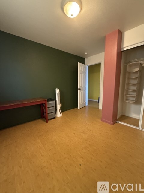 A room with a wooden floor and a green wall.