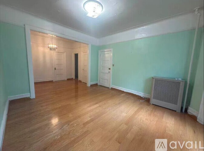 A room with wooden flooring and a ceiling light.