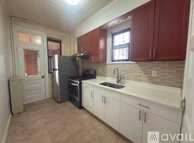 A kitchen with white cabinets and a tiled backsplash.