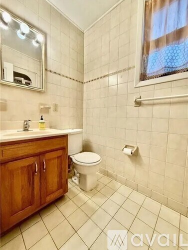 A bathroom with a toilet, sink, and mirror.