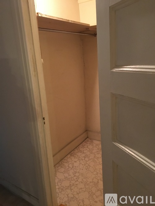 A small, empty room with patterned flooring and a door on the right.
