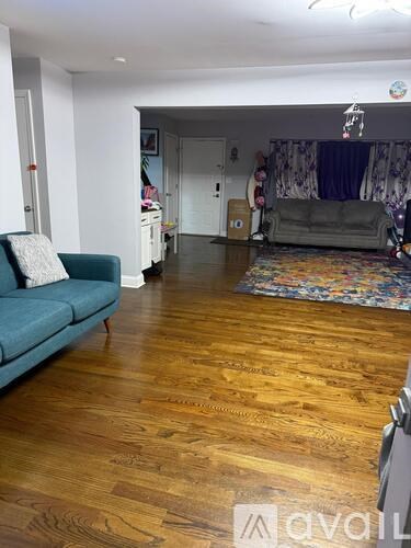 A living room with a blue couch and wooden floors.