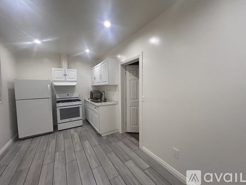 A kitchen with white appliances and cabinets.
