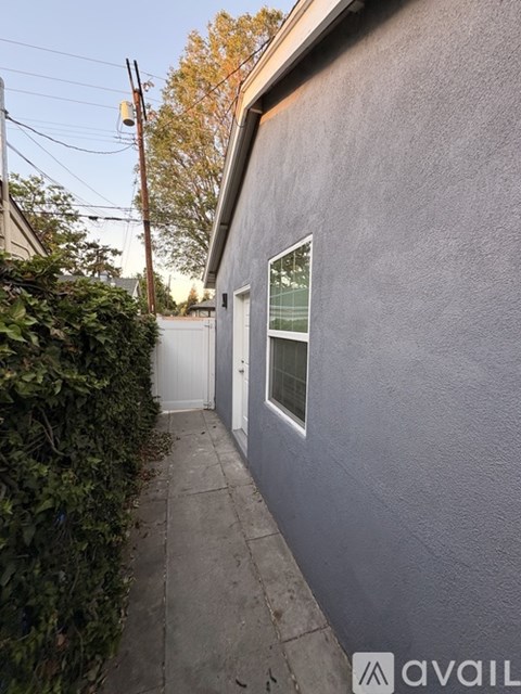 A grey building with a white door and a window.