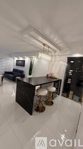 A modern kitchen with a black countertop and gold accents.