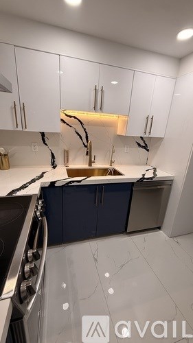 A kitchen with white cabinets and a blue island.