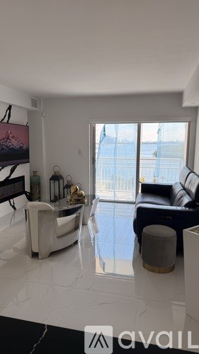 A living room with a black couch and a white chair.