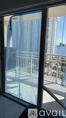 A view from inside a building looking out to a balcony with a railing.