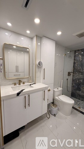 A bathroom with a white sink and toilet.