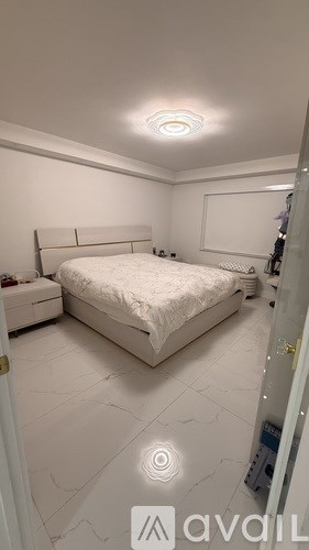 A bedroom with a large bed and a white dresser.