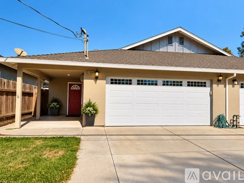 A house with a red door and a white garage door.