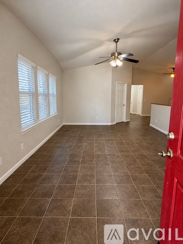 A room with a red door and a ceiling fan.