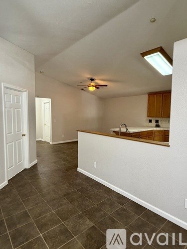 A kitchen area with tile flooring and a ceiling fan.