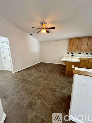 A room with a ceiling fan and tile flooring.
