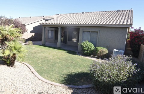 A house with a brown roof and a gravel driveway.