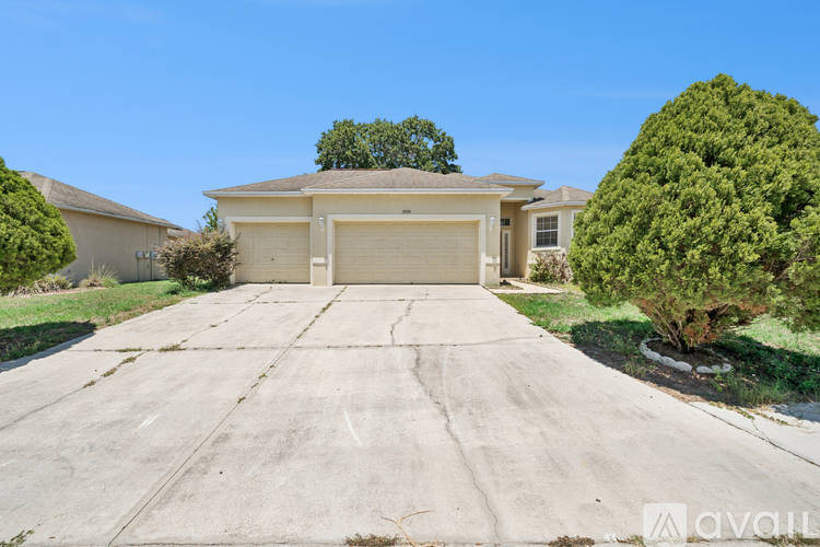 A house with a garage and a driveway in front of it.