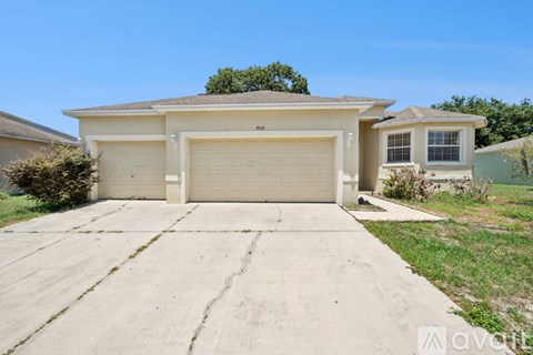 A two-car garage is attached to a beige house.