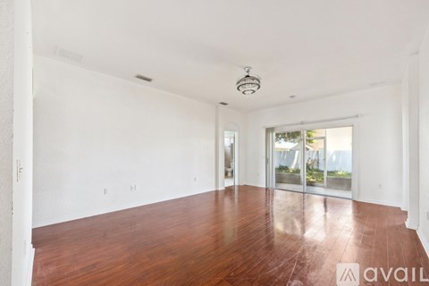 A spacious room with wooden floors and white walls.