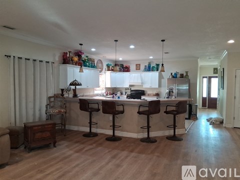 A kitchen with a bar area and wooden floors.