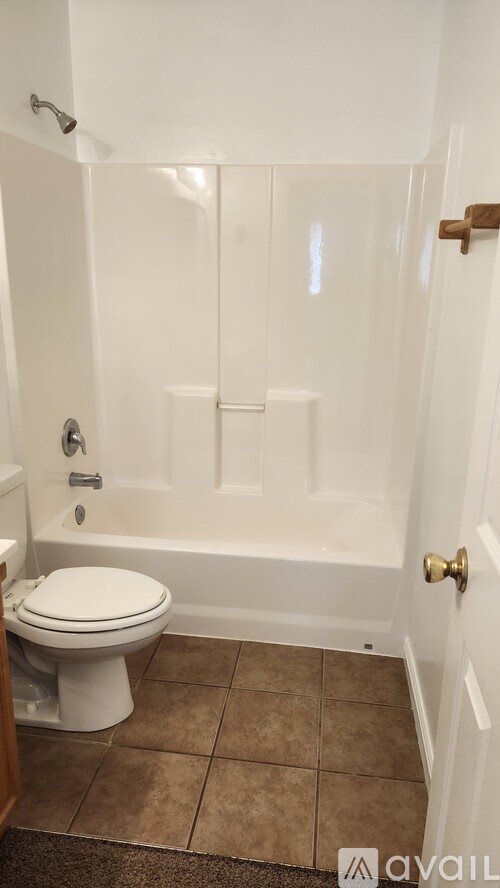 A white toilet in a small bathroom with beige tiles.