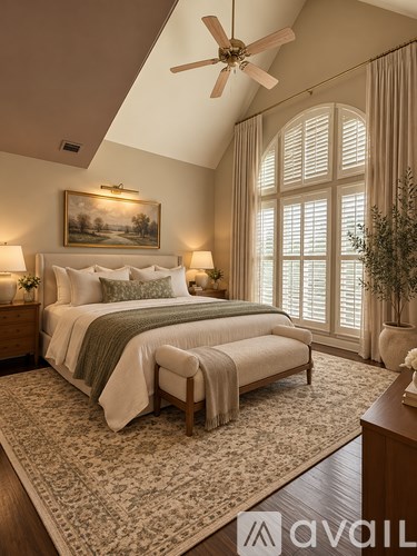A bedroom with a large bed and a ceiling fan.