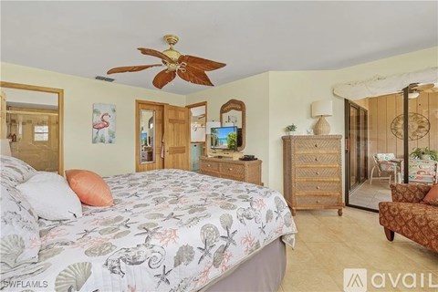 A bedroom with a large bed and a ceiling fan.