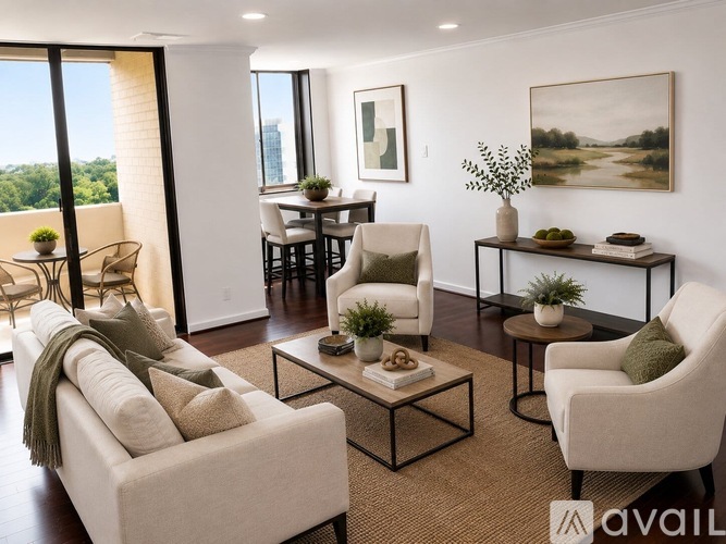 A living room with a sofa, chairs, and a table with a vase of flowers on it.