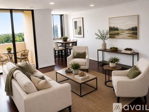 A living room with a sofa, chairs, and a table with a vase of flowers on it.