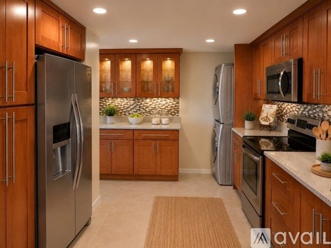 A kitchen with wooden cabinets and a refrigerator.