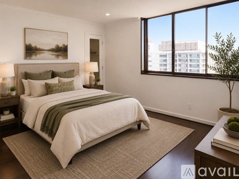 A bedroom with a large bed and a painting on the wall.