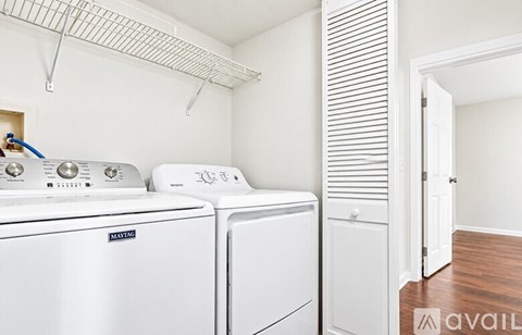 A white Maytag washing machine and dryer in a small laundry room.