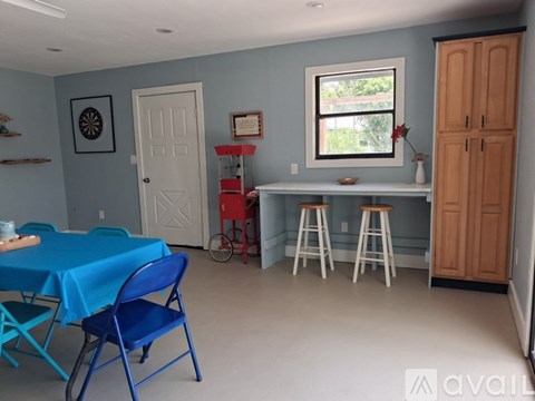 A dining area with a blue tablecloth and chairs.
