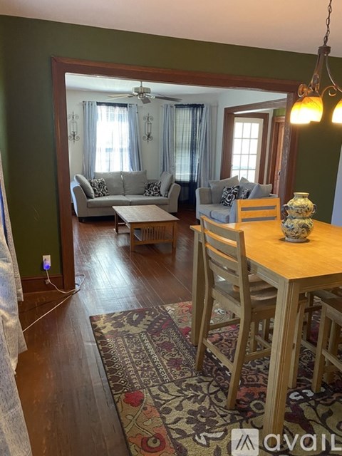 A living room with a couch, a table, and a rug.