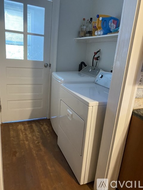 A white washing machine sits in a small laundry room.