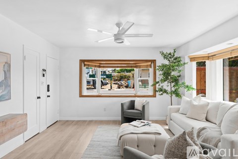 A living room with a white couch and a ceiling fan.