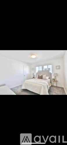 A bedroom with a bed, nightstand, and lamp.