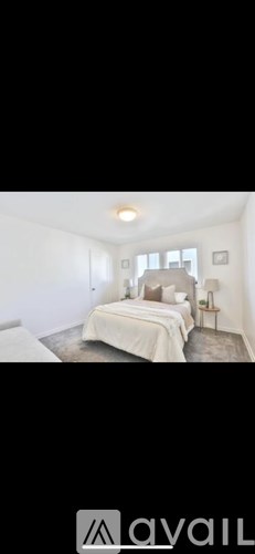 A bedroom with a bed, nightstand, and lamp.
